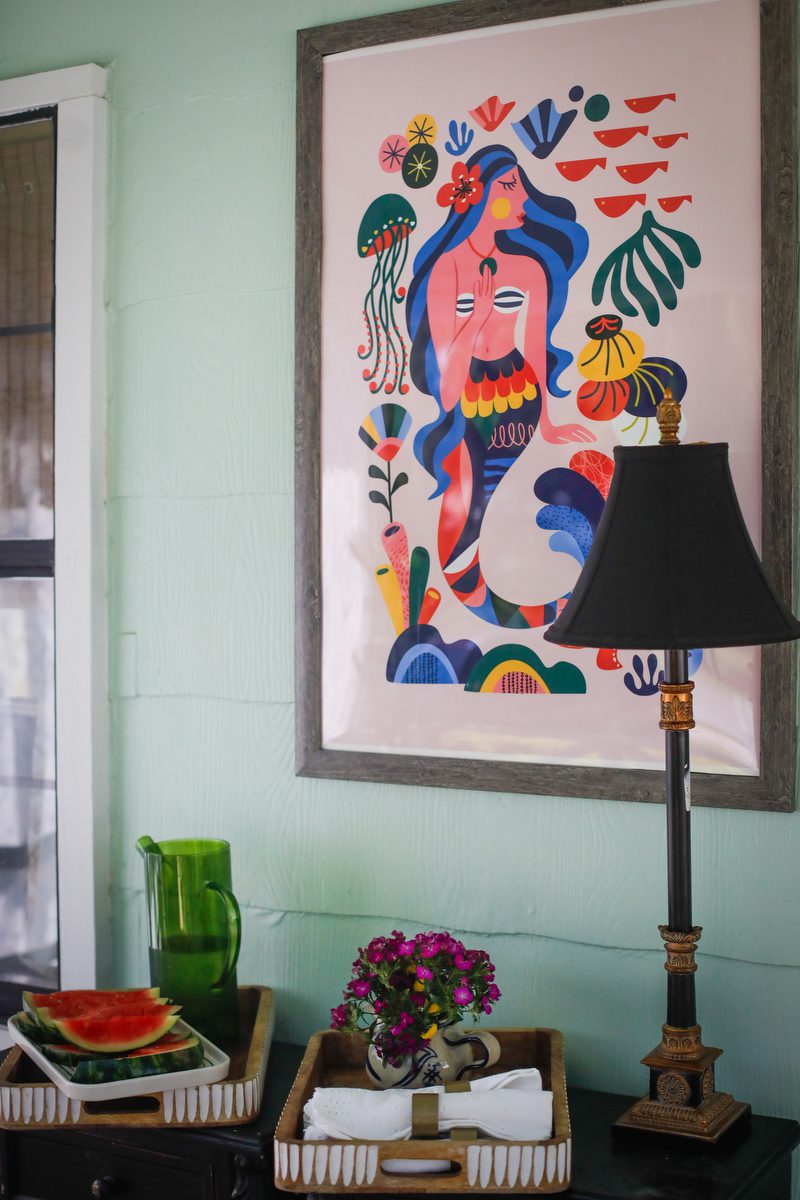 A picture of a mermaid on a front porch.