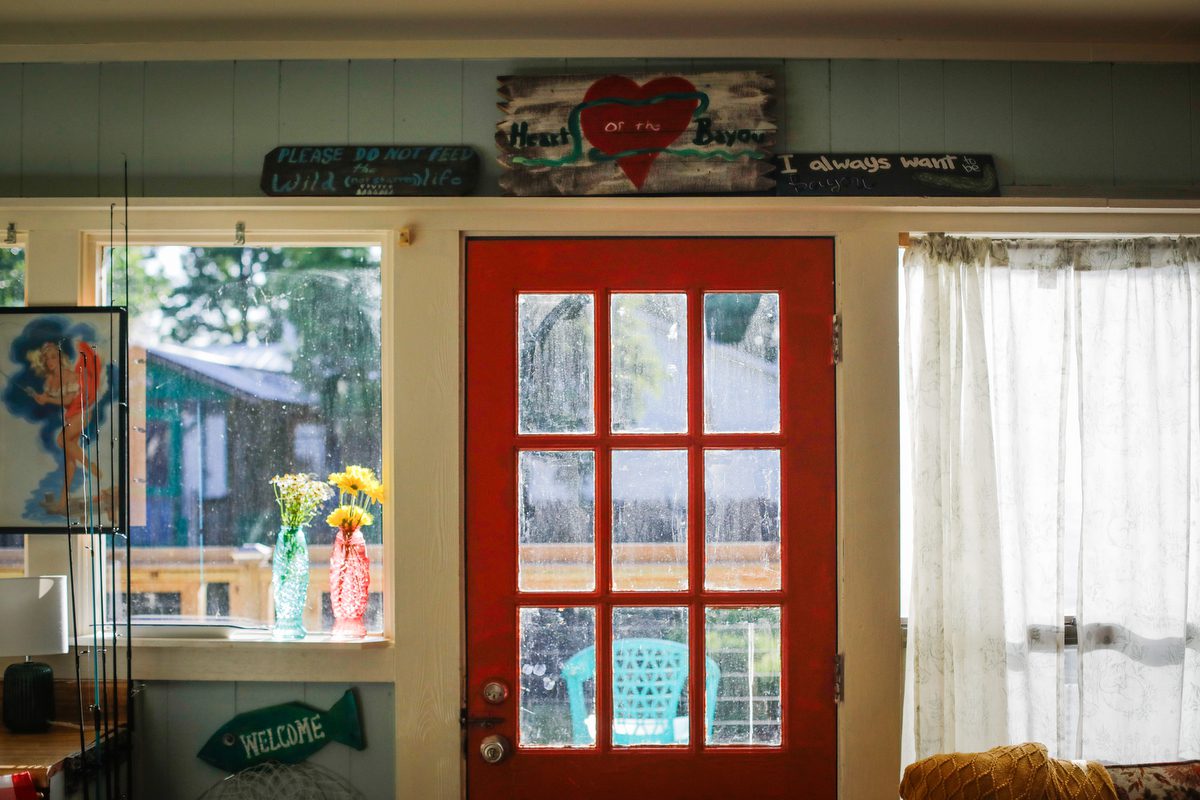 A picture of a red door looking out onto a bayou.