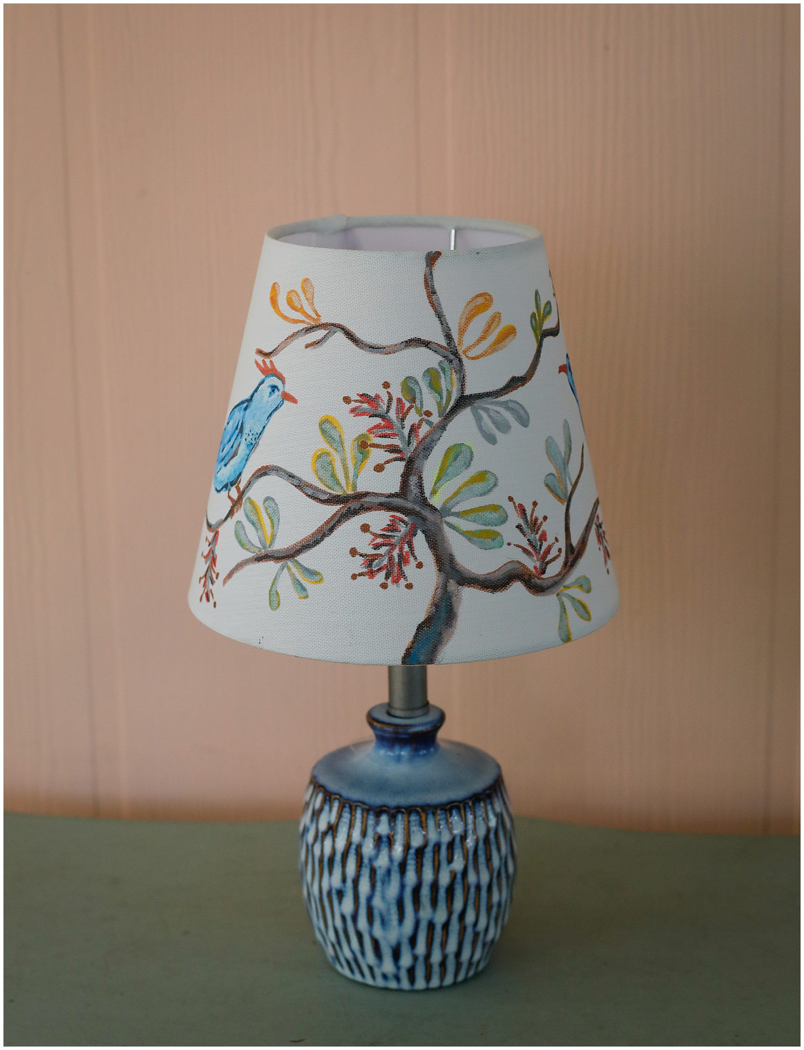 a lampshade with a hand-drawn bird and tree